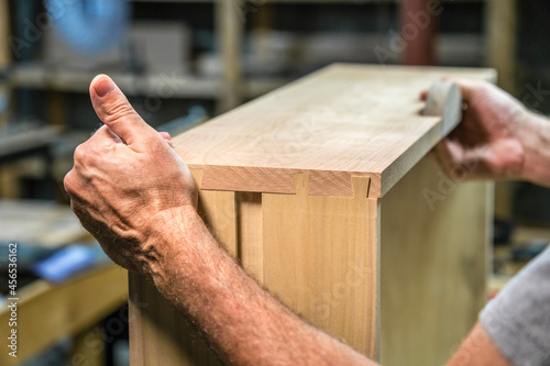 Woodworker fitting together dovetail joints.