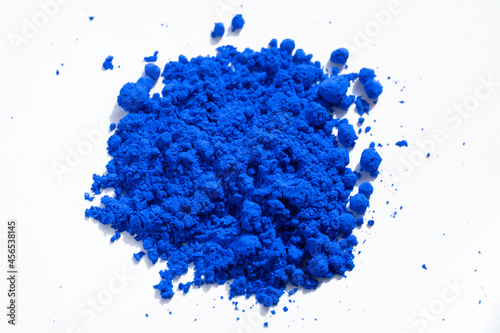 Close up of a portion of blue pigment isolated on white seen from above. The pigment will be mixed with linseed oil to make oil paint