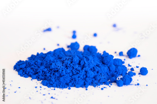 Close up of a portion of ultramarine , cobalt or indigo blue pigment isolated on white in side view. The pigment will be mixed with linseed oil to make oil paint