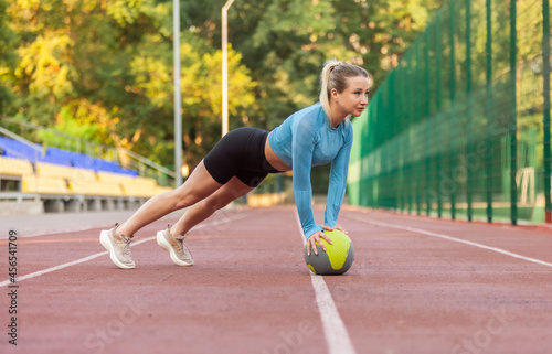 Athletic woman push up on medicine ball at stadium © splitov27