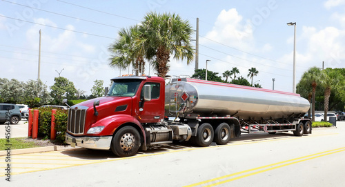 Fuel truck delivering gas at a local gas station.  Long lines of cars wait their turn at the fuel pump in Davie, Florida, USA.  photo