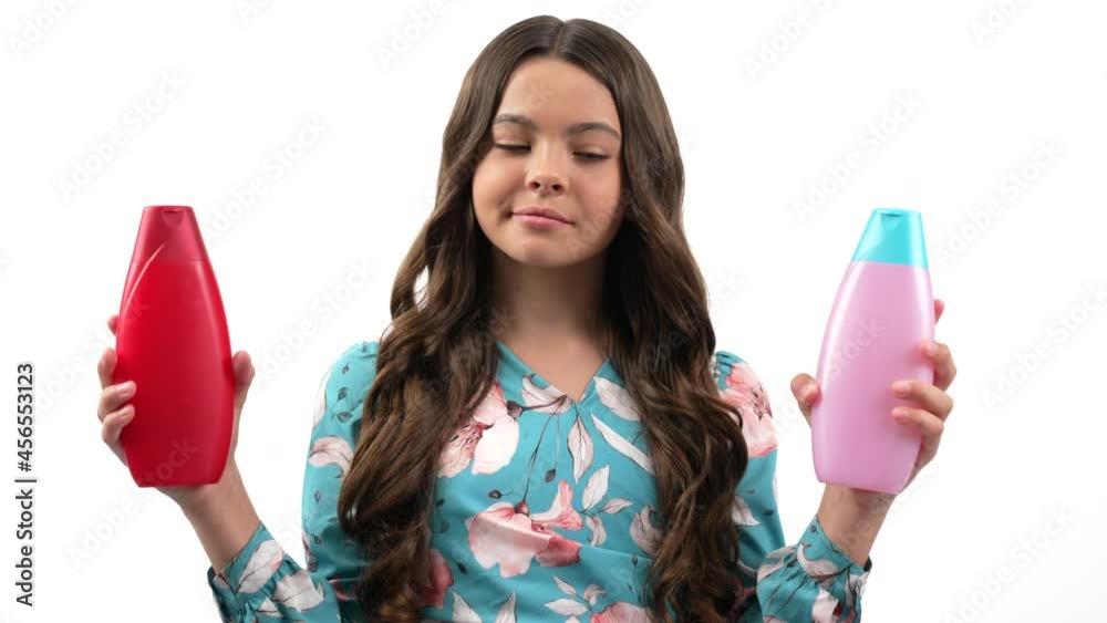 smiling kid girl choosing product of skin lotion or shower gel in bottle, conditioning treatment. smiling kid girl choosing product of skin lotion or shower gel in bottle, conditioning treatment.