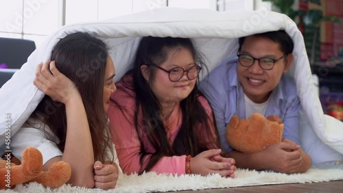 Family with Autism is playing under the blanket at home for disability child care concept.