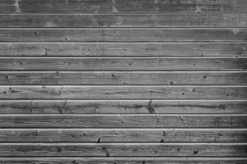 Front view of weathered gray wood boards wall. High resolution full frame textured background in black and white. Copy space.