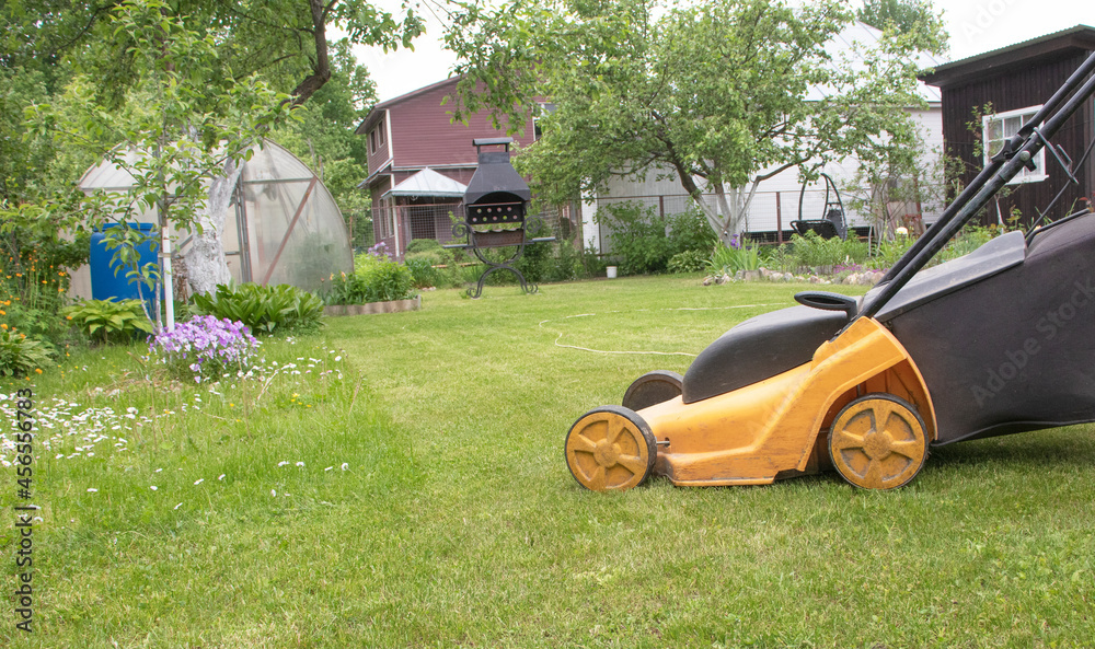 Man mows grass with a lawn mower