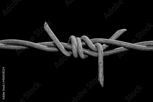 Barbed wire on black background. Frontier. 