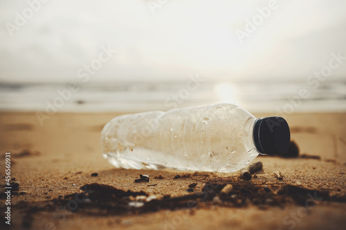 Plastic water bottles pollution on beach sunset.Empty used dirty plastic bottles.