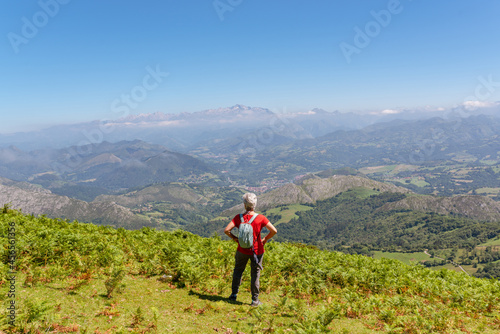 senior woman hiker contemplates the landscape from the top of a mountain © Alberto