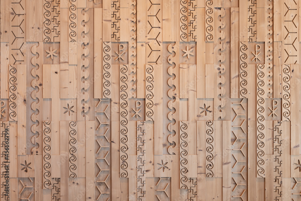 Milled and cut stone pine wooden wall with different patterns and symbols