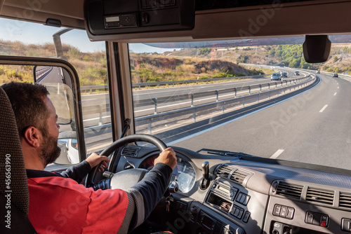 Photographie Truck driver driving on the highway, seen from inside the cab.
