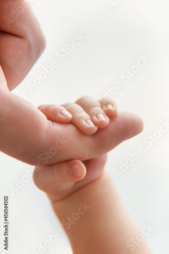 Baby hand holding father finger. Lovely, emotional moment. Closeup. Hand of the child in a hand of father.