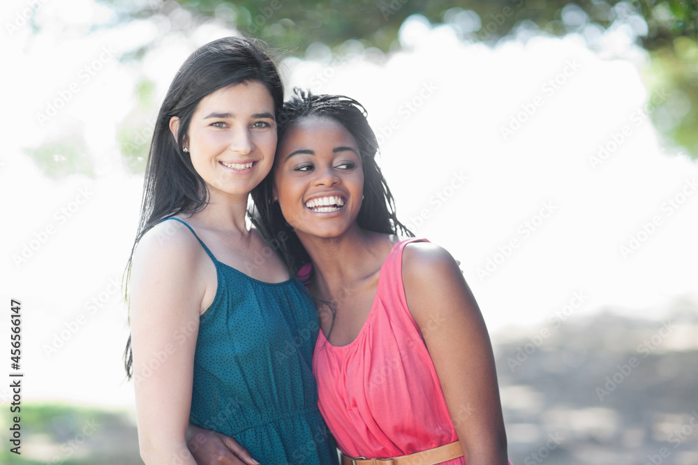 Smiling women hugging outdoors Smiling women hugging outdoors
