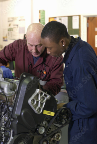 Teacher helping student with car engine