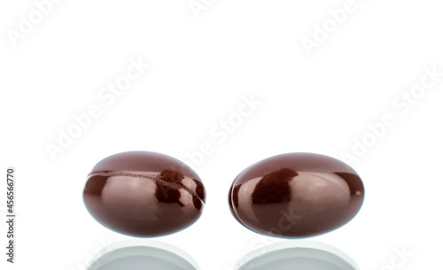 Two medical pills in a capsule, close-up, isolated on white.