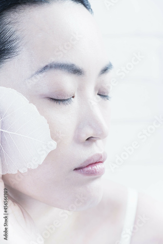 Photos Woman wiping leaves on her face