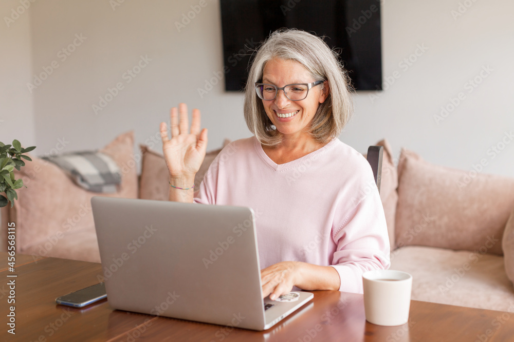 Happy middle-aged woman making video call on laptop Happy middle-aged woman making video call on laptop