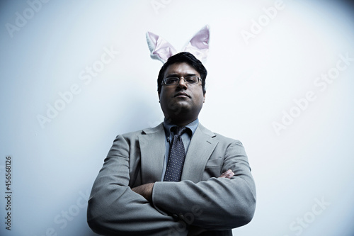 Slika na platnu Studio portrait of businessman wearing bunny ears