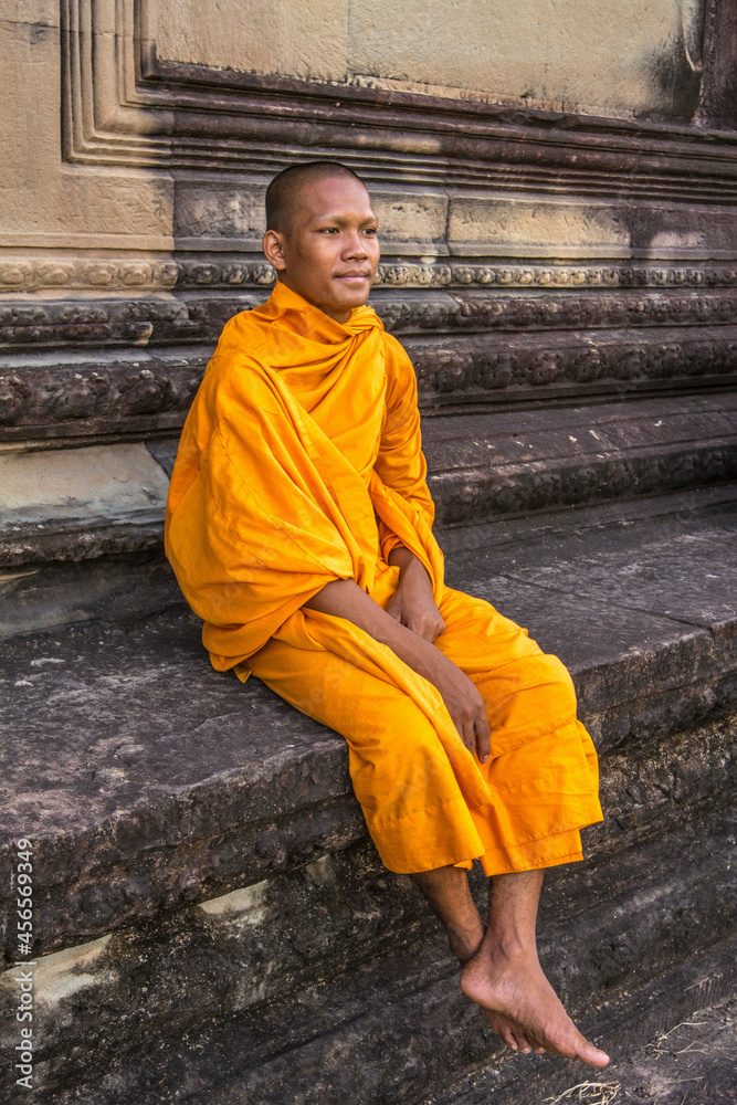Fototapeta premium Young Buddhist monk sitting at temple in Angkor Wat, Siem Reap, Cambodia