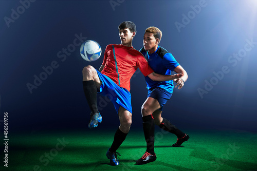 Male soccer players defending ball