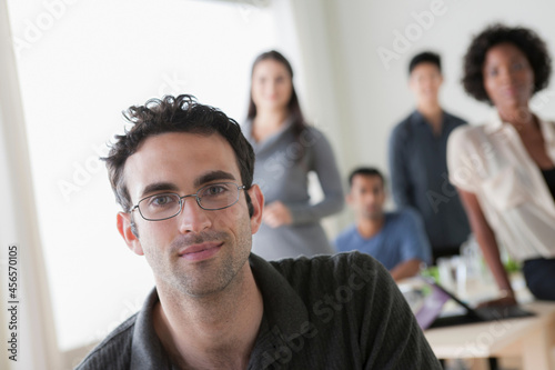 Canvas Print Portrait of male office worker in front of colleagues