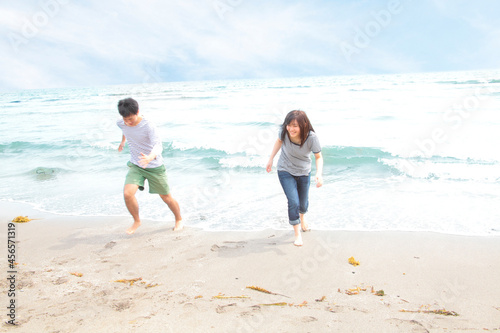 Young couple running away from tide