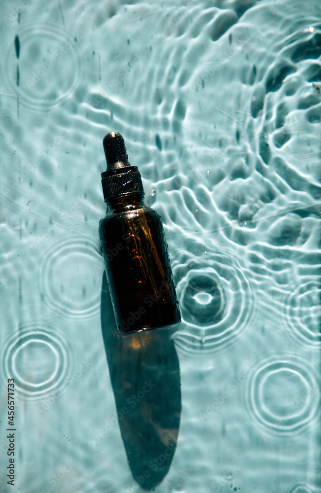 glass bottle with face serum on water drops
glass bottle with face serum on water drops