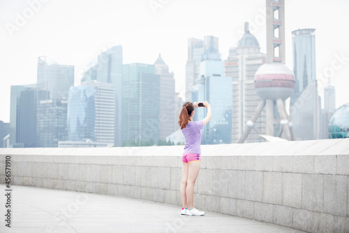 Photography Young woman taking photograph of buildings in Pudong, Shanghai, China