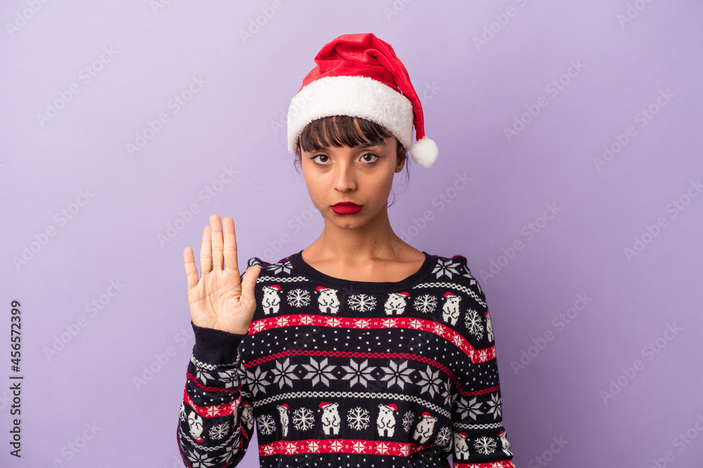 Young mixed race woman celebrating Christmas isolated on purple background standing with outstretched hand showing stop sign, preventing you. Young mixed race woman celebrating Christmas isolated on purple background standing with outstretched hand showing stop sign, preventing you.