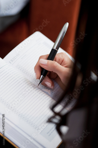 Close up of secretary making notes at meeting