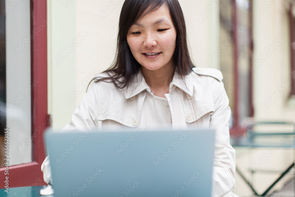 Mid adult woman using laptop outdoors Mid adult woman using laptop outdoors