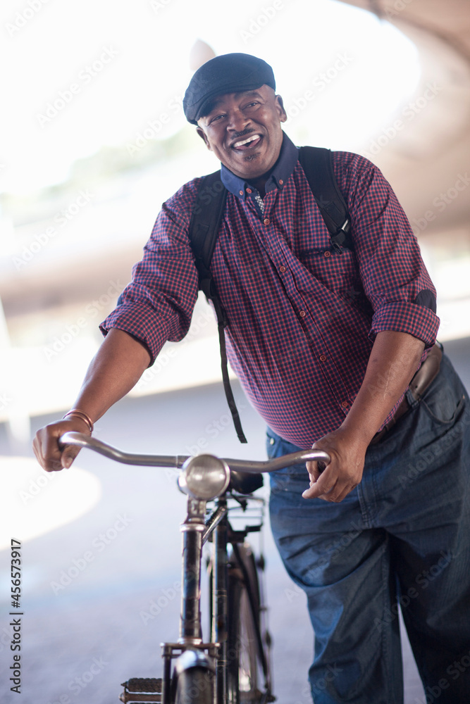Senior man pushing bicycle through city underpass Senior man pushing bicycle through city underpass