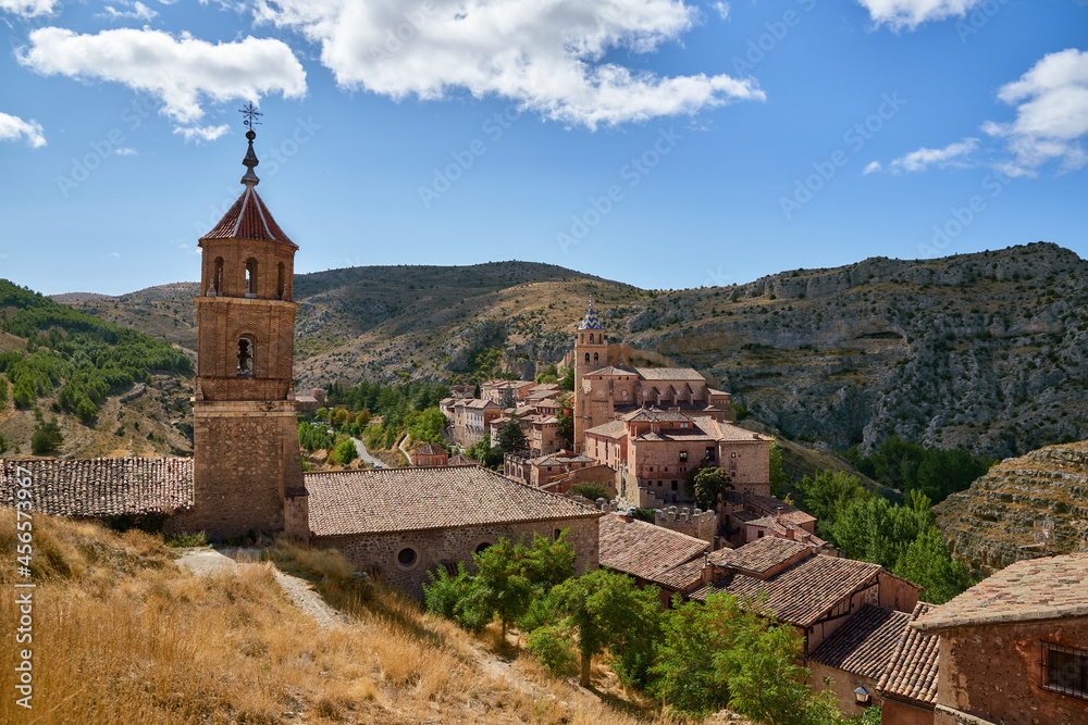View of an old town with a bell tower surrounded by mountains