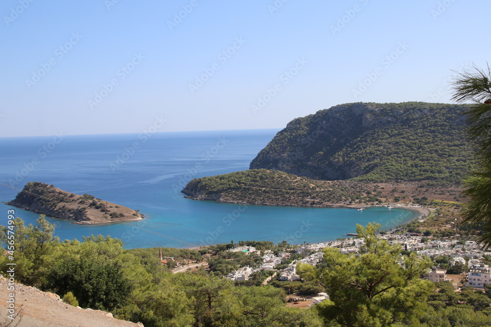 Bay and island view with hills and trees around it.