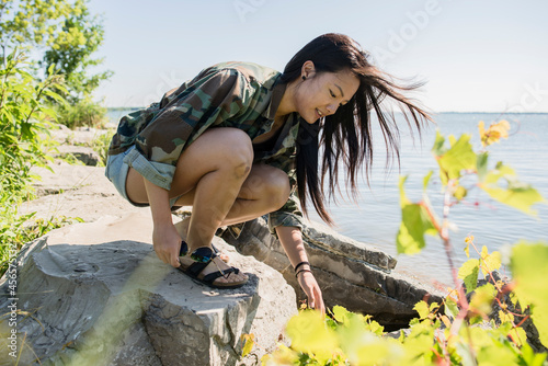 Mid adult woman crouching on rocks