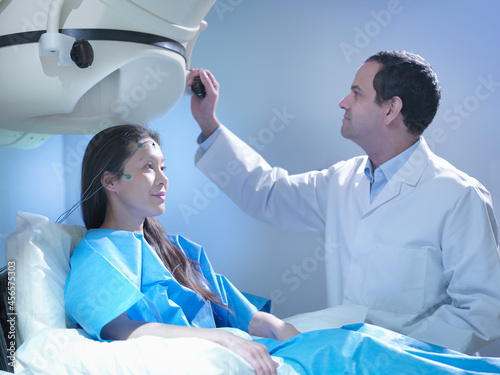 Doctor treating patient using magnetoencephalography (MEG) scanner photo