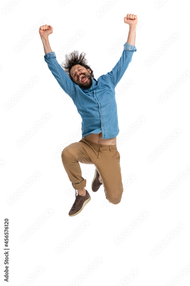 casual young man celebrating success jumping in the air casual young man celebrating success jumping in the air