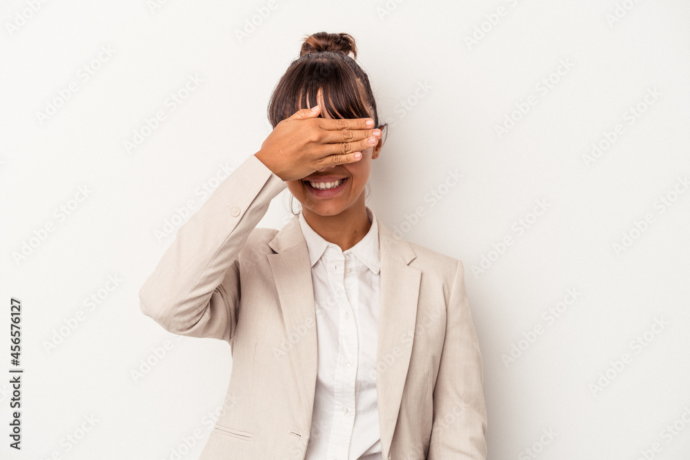 Young mixed race woman isolated on white background covers eyes with hands, smiles broadly waiting for a surprise. Young mixed race woman isolated on white background covers eyes with hands, smiles broadly waiting for a surprise.