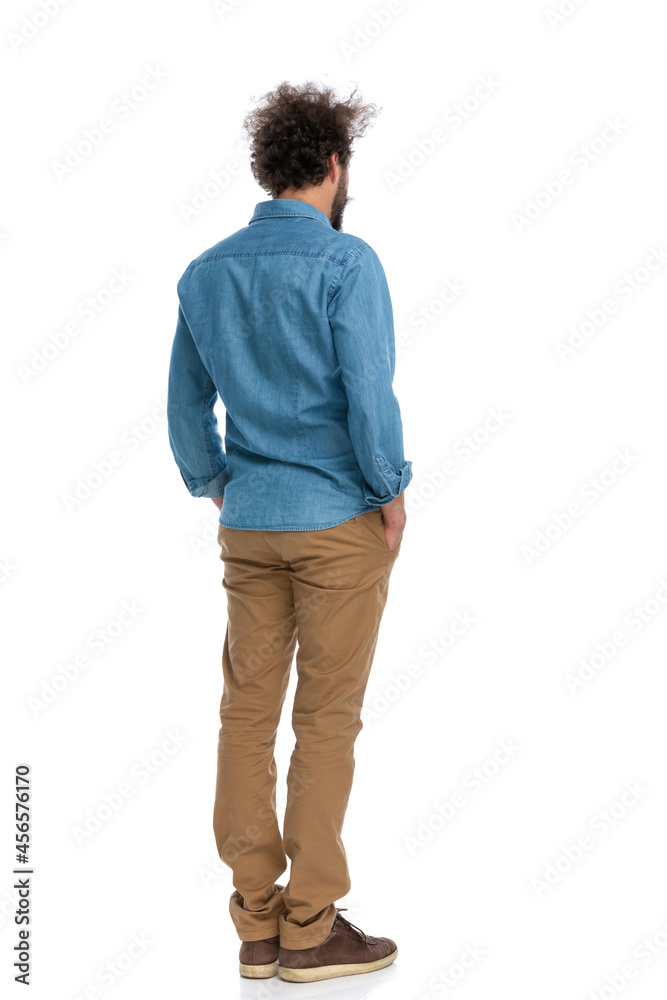 handsome casual man standing with his back at the camera handsome casual man standing with his back at the camera