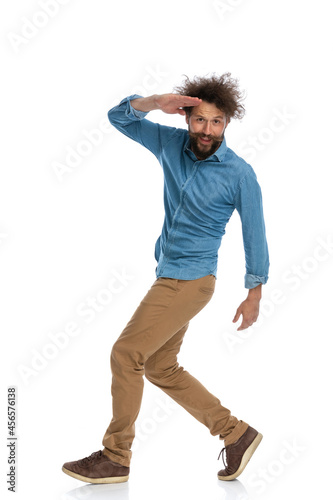 young casual man saluting with one hand on his forehead