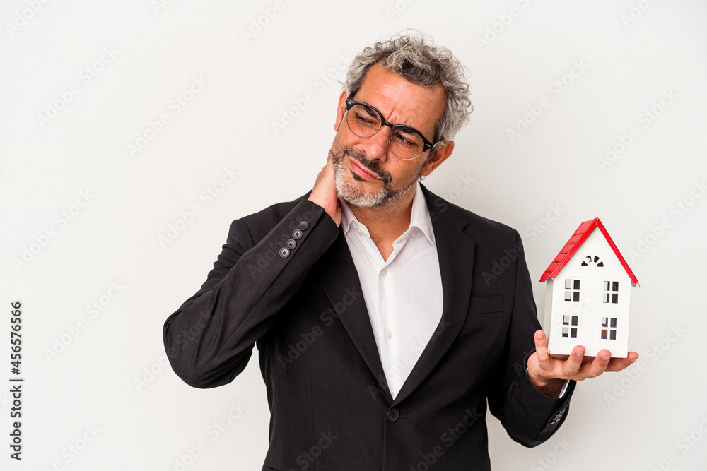 Middle age business man holding bills and house model isolated on blue background  touching back of head, thinking and making a choice.