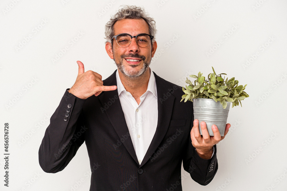 Middle age business man holding a plant isolated on white background showing a mobile phone call gesture with fingers. Middle age business man holding a plant isolated on white background showing a mobile phone call gesture with fingers.