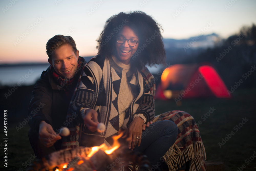 Couple toasting marshmallows at camp, Isle of Skye, Scotland