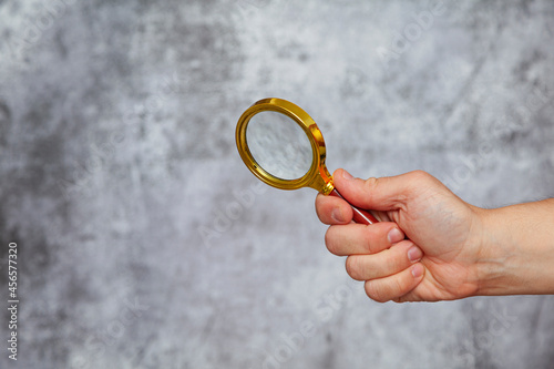 Human hand holding a magnifying glass