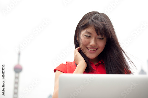 Photography Young woman using laptop, outdoors, Shanghai, China