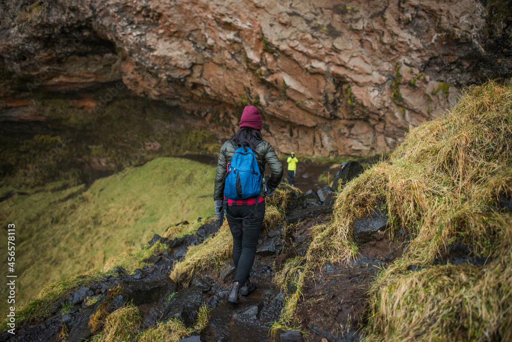 Two tourists walking down path at Seljalandsfoss waterfall, Iceland Two tourists walking down path at Seljalandsfoss waterfall, Iceland