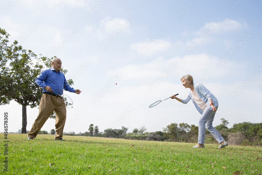 Senior couple playing badminton in park