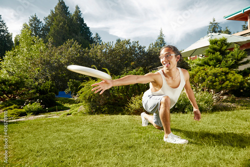 Tableau sur toile Man playing frisbee in field