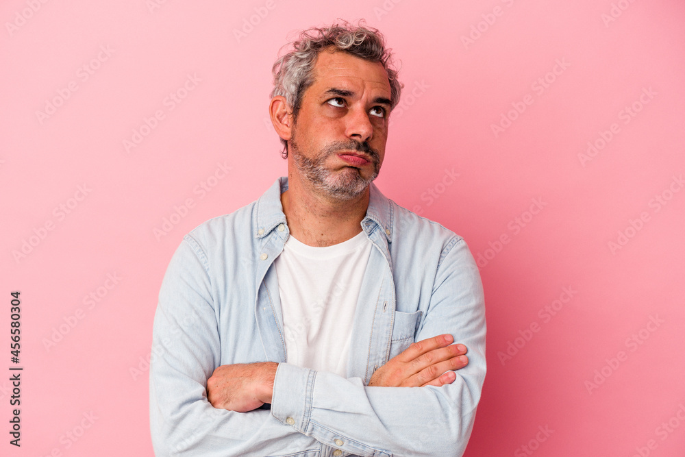 Middle age caucasian man isolated on pink background  tired of a repetitive task.