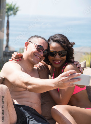 Couple taking selfie on sofa outdoors © Cultura Allies
