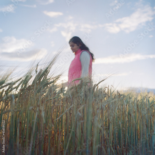 Photography Mid adult woman, walking through wheat field